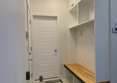 angled view of the custom bench and awning cabinets at basement entryway by Saskatoon basement developer Axium Interiors