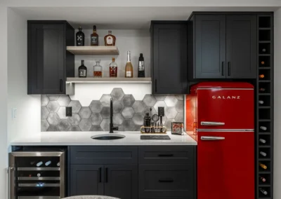 compact wet bar with built-in wide fridge, black cabinetry and red galanz fridge by Saskatoon basement developer Axium Interiors.