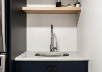 compact sink with open wood shelf and cabinetry by Saskatoon basement developer Axium Interiors