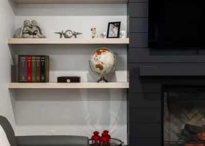 fireplace with black shiplap and floating display shelves by Saskatoon basement developer Axium Interiors